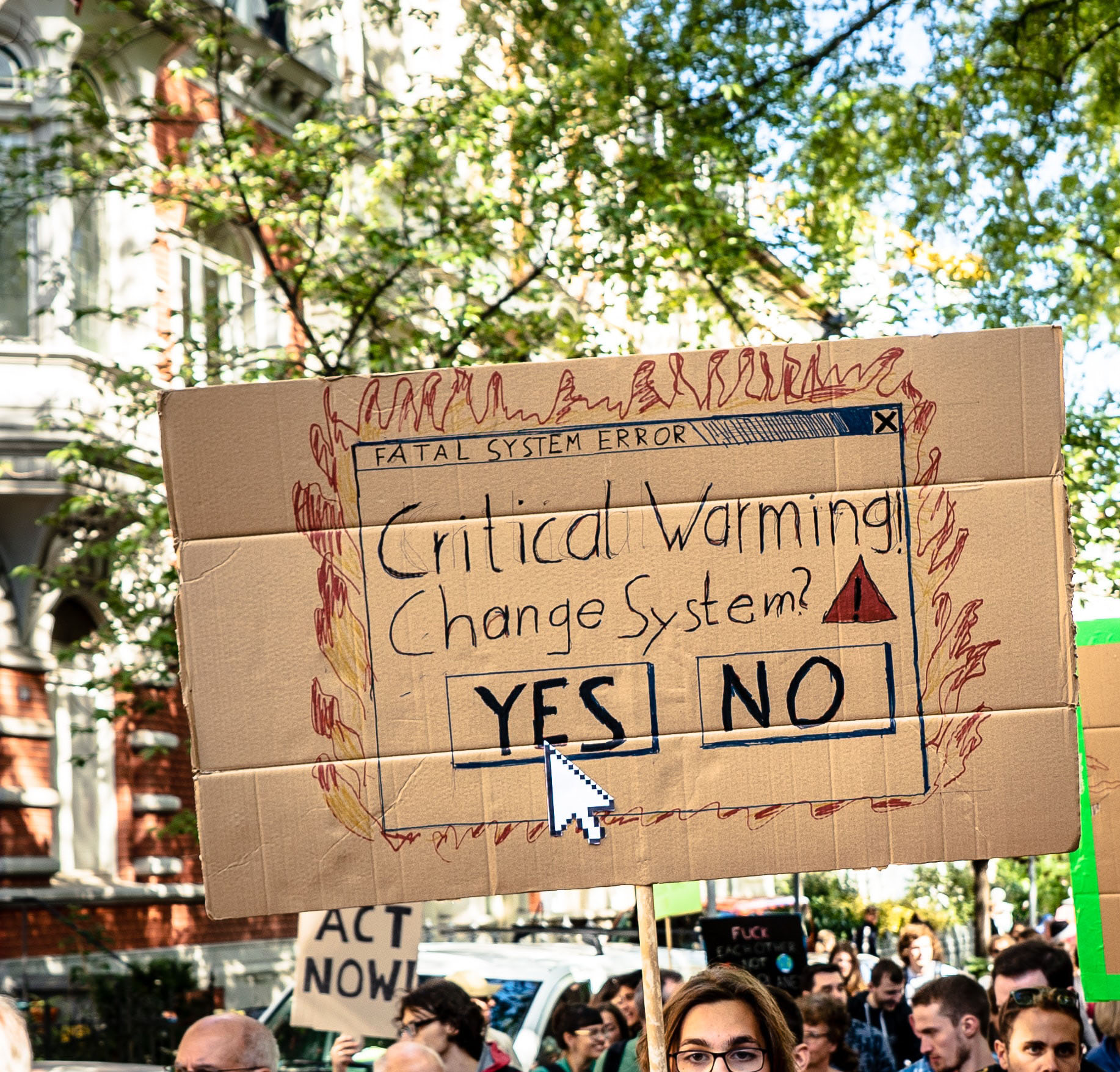 A protestor with a sign that says 'Critical warning, change system yes/no?'