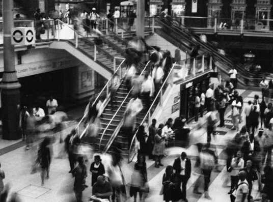 A black and white image of a crowd in a train station.