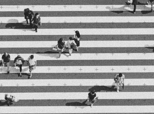 A black and white image of people crossing a white lined crosswalk, with a grid overlay