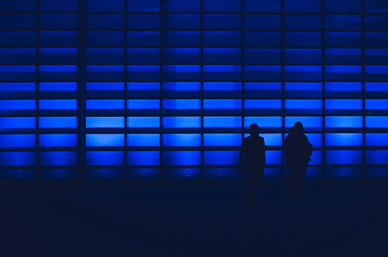 Two figures in blue light