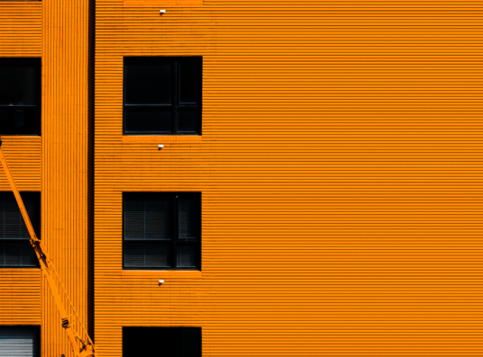 A construction worker on an orange building