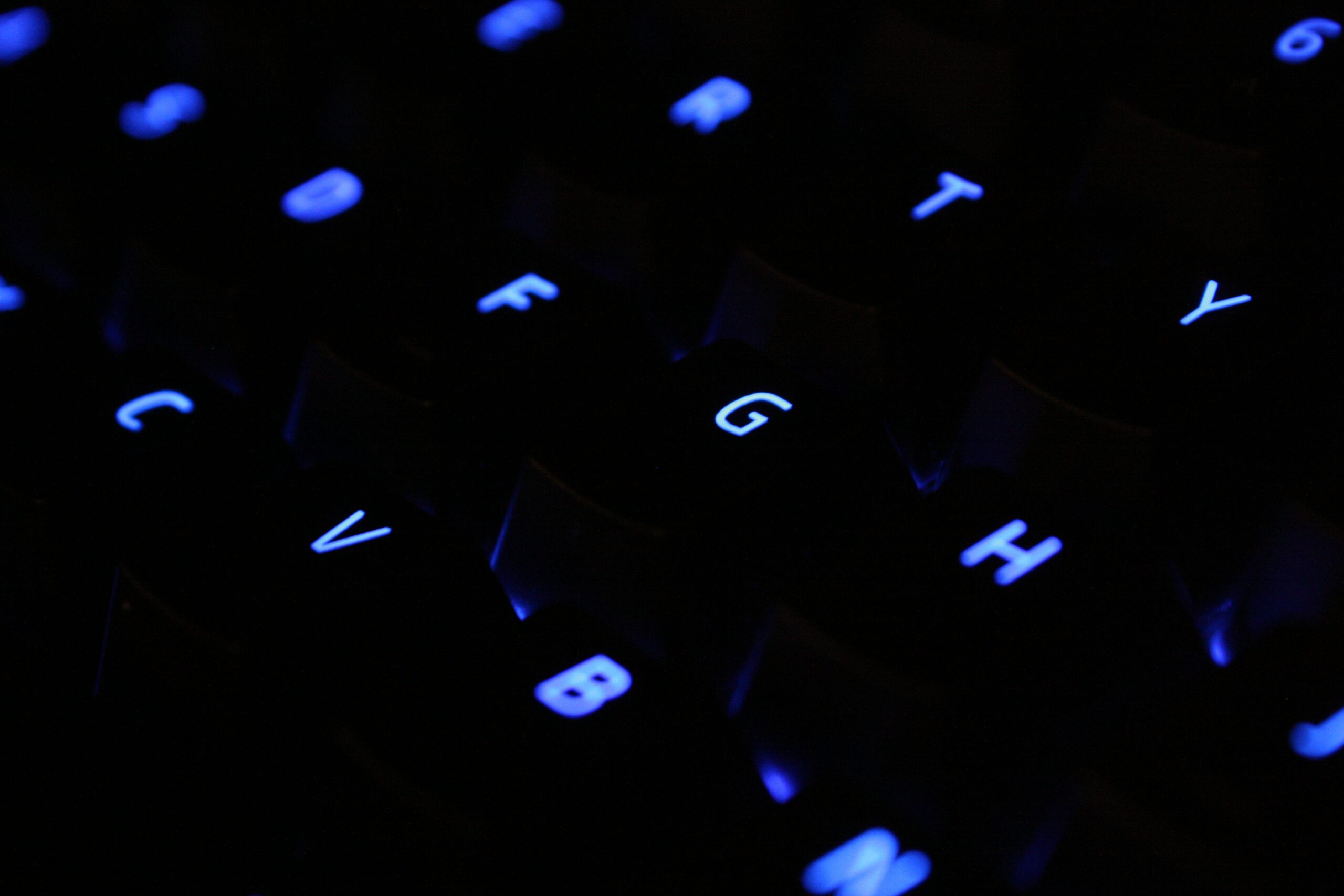 A close-up of a computer keyboard with light-up blue keys