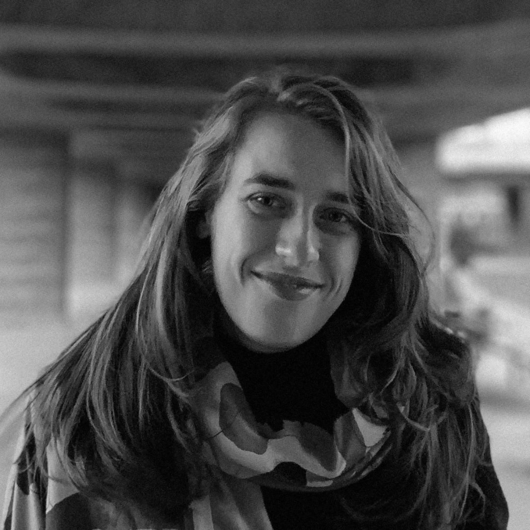 A black and white photo of Julia Rone. She has long hair and a cotton scarf