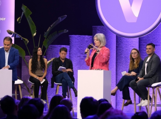 Gina standing at a white podium at the VivaTech 2024 New York Times Debate stage.